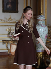 A woman wears a double-breasted black dress